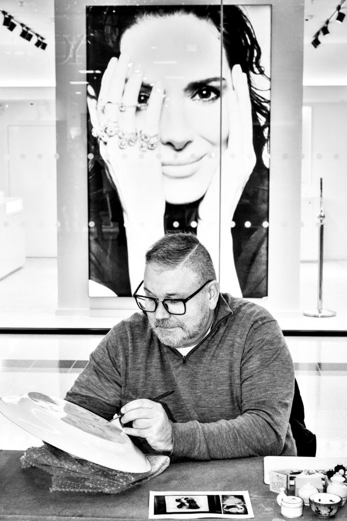 Portrait photograoph of ceramic artist Jon Frence, by photographer Jerome Whittingham. Jon is demonstrating ceramic illustration techniques to the public in The Potteries Centre, Hanley.