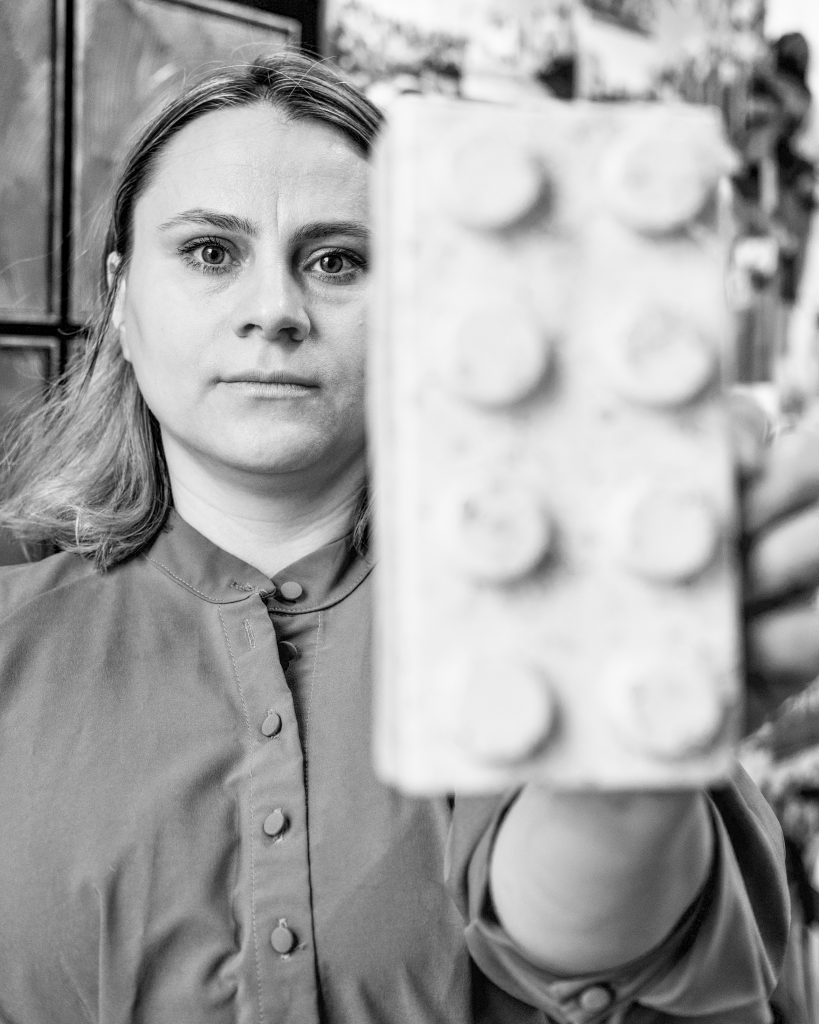 Ukrainian Artist Yuliia Holovatiuk-Ungureanu holding a ceramic brick, from her exhibition On The Edge